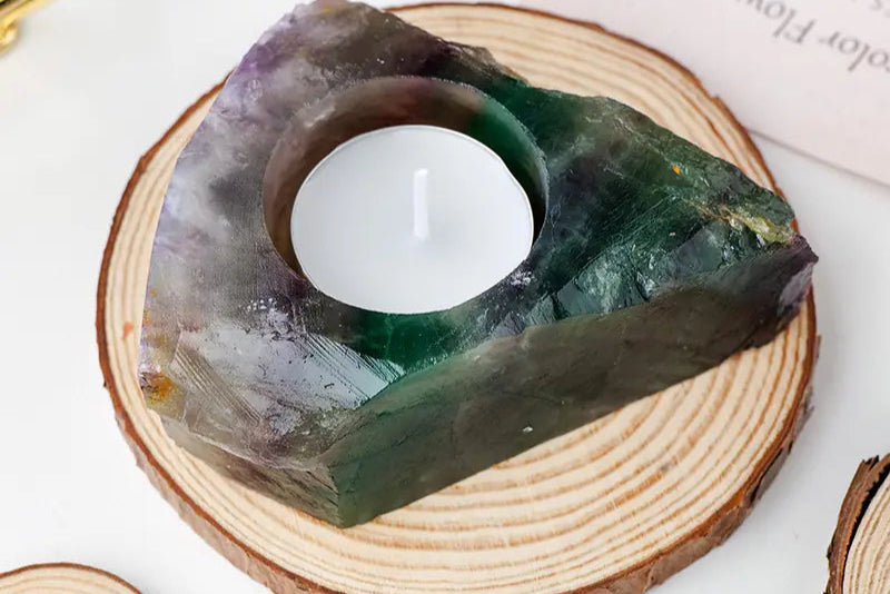 Decorative stone with a candle on a wooden base, featuring text in a red box at the top left corner.