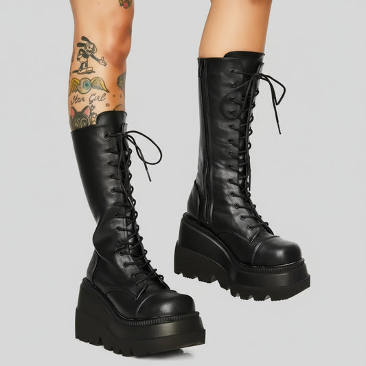 Black platform boots with high laces on a white background