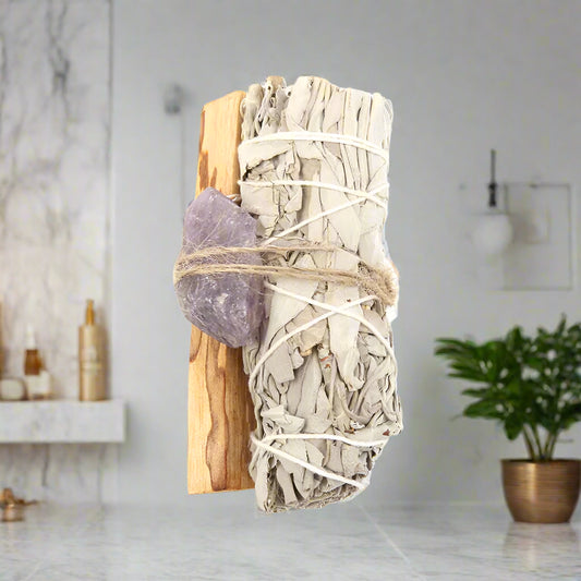 Bundled sage with amethyst crystal on a white background