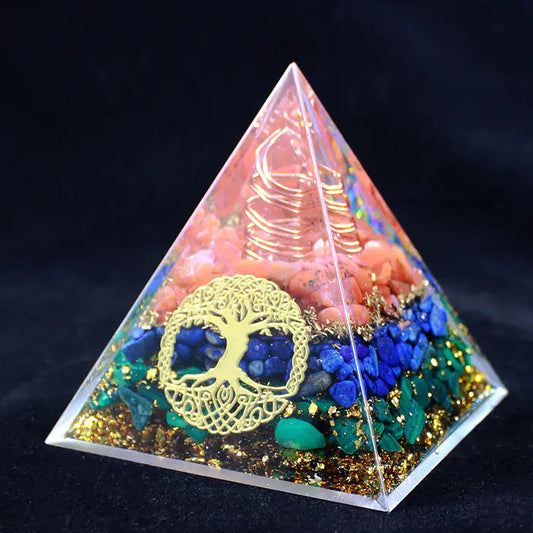 Pyramid-shaped decorative item with colorful stones and a tree of life symbol on a dark background