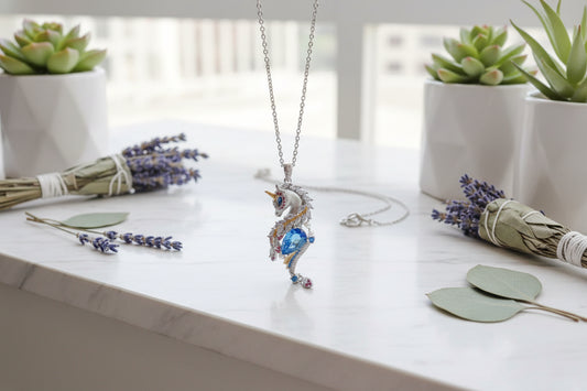 Unicorn-shaped pendant with blue gemstone on a finger