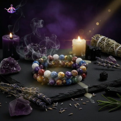 Colorful chakra beads arranged in a circle with a silhouette of a meditating person in the center.