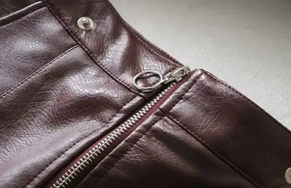 Close-up of a brown leather wallet with a zipper on a neutral background