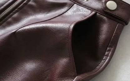 Close-up of a brown leather jacket with a button