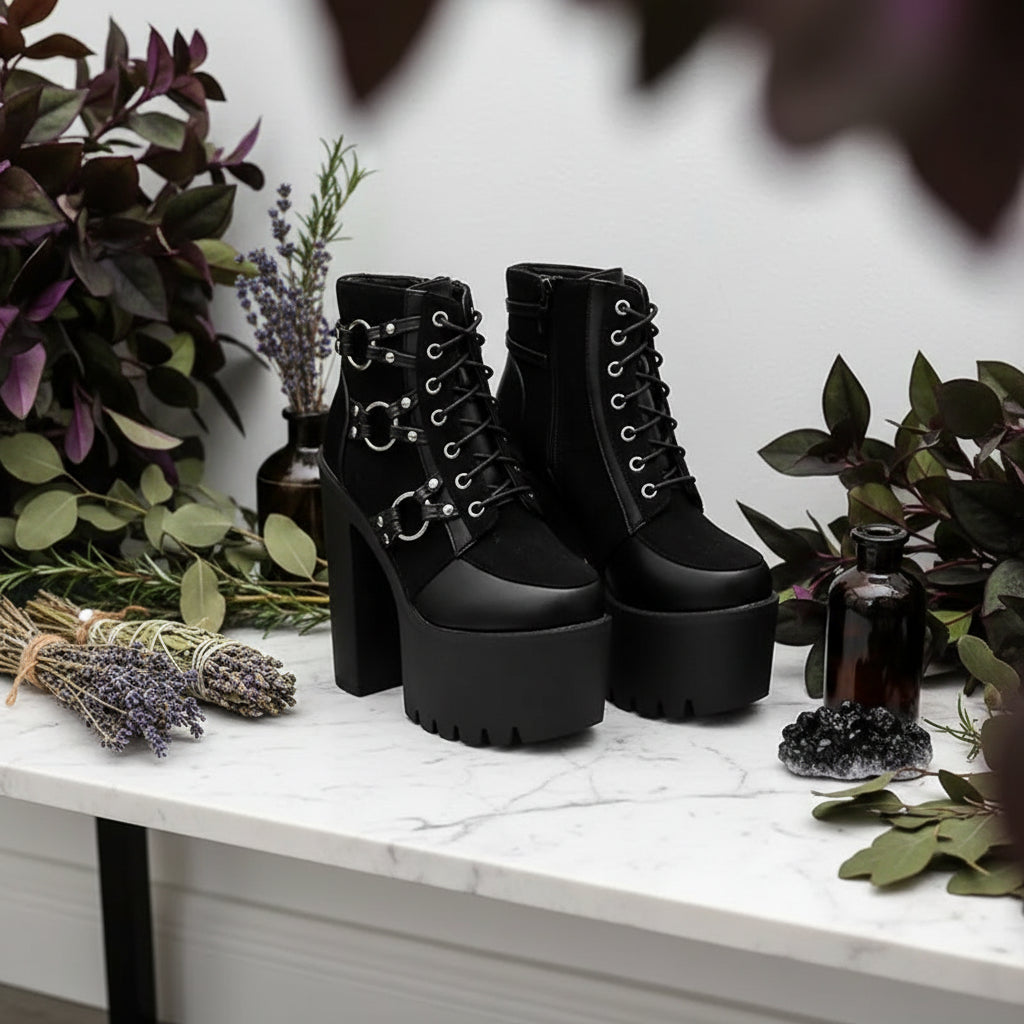 Black platform boots with chunky heels and metal accents on a white background