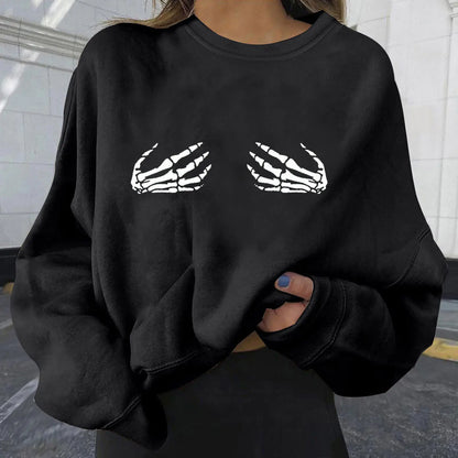 Black sweatshirt with skeleton hand design worn by a person.