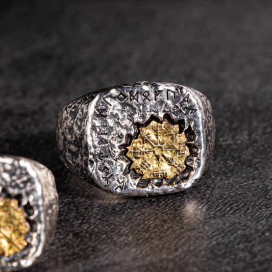 Silver ring with gold center on a dark textured surface