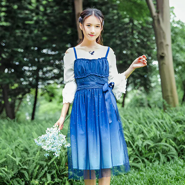 Woman in a blue dress holding flowers in a park