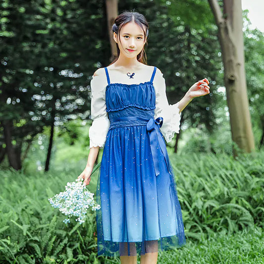 Woman in a blue dress holding flowers in a park