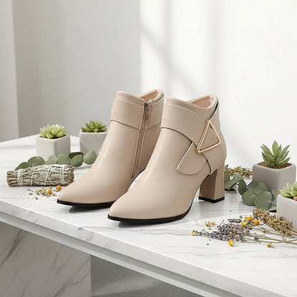 Beige ankle boots with a high heel worn by a person on a city street.