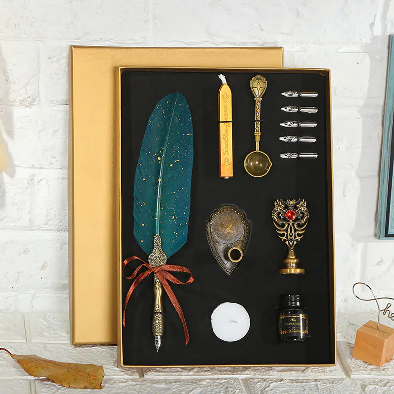 Decorative set with a feather pen, ink bottle, and other accessories in a black box with gold lid.