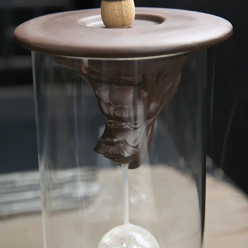 Ceramic incense burner with a glass container on a blurred background