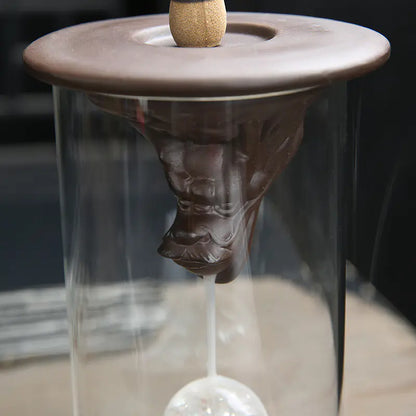 Ceramic incense burner with a glass container on a blurred background