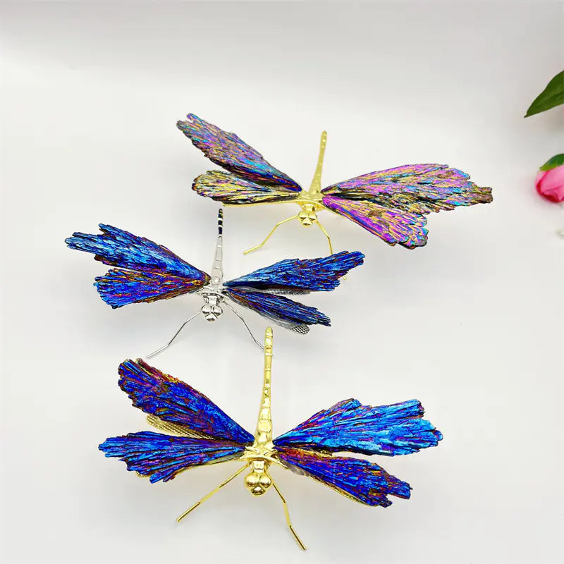 Three butterfly-shaped decorative items with iridescent wings on a white background