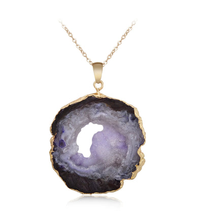 Geode pendant necklace with gold rim on a white background