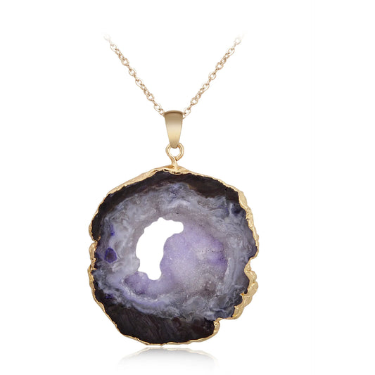 Geode pendant necklace with gold rim on a white background