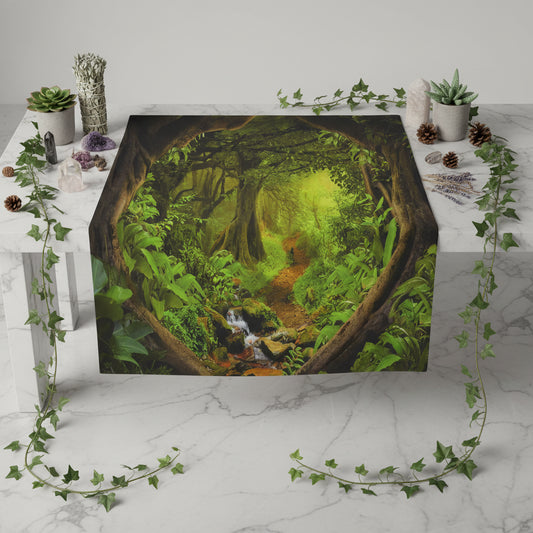Tapestry depicting a lush green forest with a stream, hanging on a wall above a wooden floor.