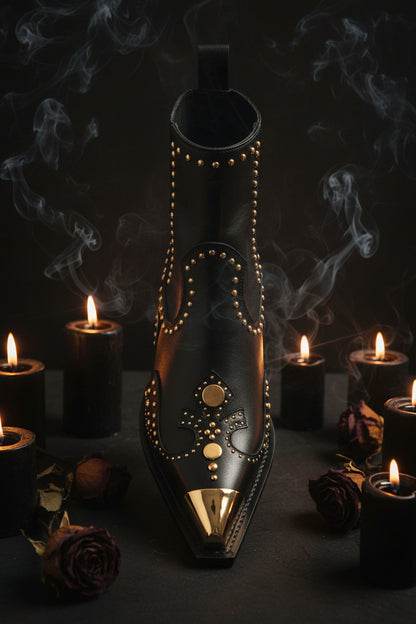 Black boot with gold studs on a white background
