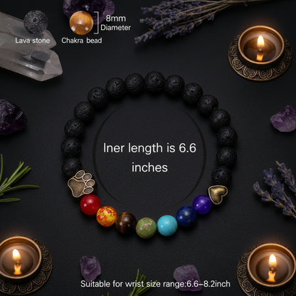 A beaded bracelet made of black lava stone beads with a sequence of colorful chakra beads (red, orange, brown, green, light blue, dark blue, purple) and two metallic accent beads. The image includes text overlays detailing the product specifications, dimensions, and suitability for a wrist size range.