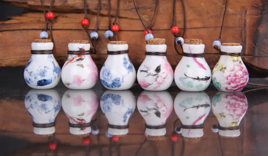 Decorative light bulb-shaped vases with artistic designs on a reflective surface.
