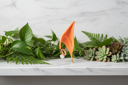 Orange elf ear with gold accents on a white background