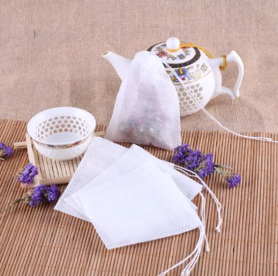 Tea bags with a teapot and lavender flowers on a textured surface