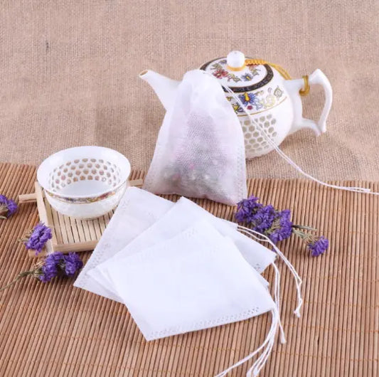 Tea bags with a teapot and lavender flowers on a textured surface
