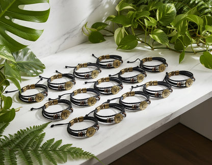 Set of twelve black leather bracelets with gold and bronze accents on a white background