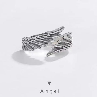 Silver angel wing ring on a light gray background with 'Angel' text below.