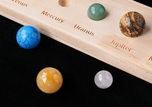 Wooden model of planets on a black background with text about the universe.