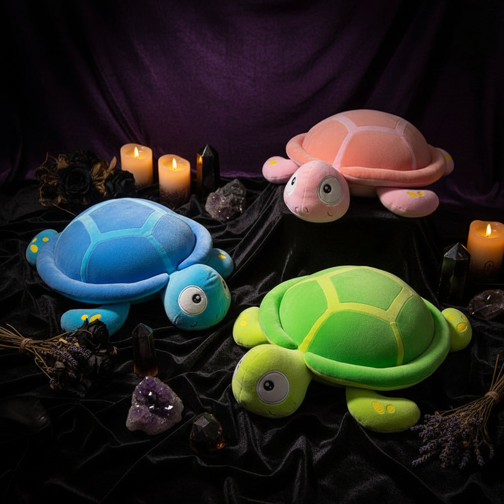 Three colorful plush turtles on a wooden floor with a magazine.