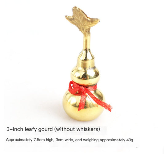 Gold decorative gourd with a red bow on a white background