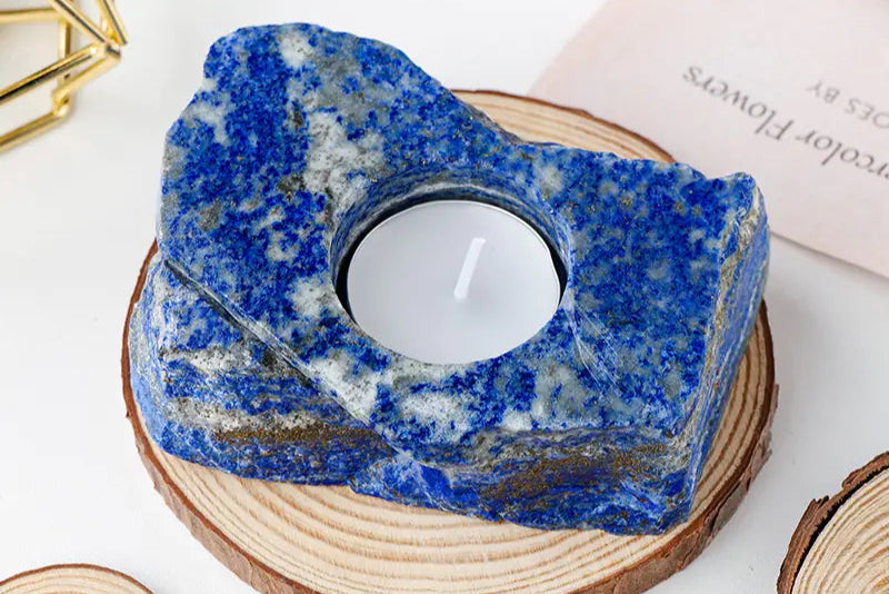 Blue stone candle holder with a white candle on a wooden base