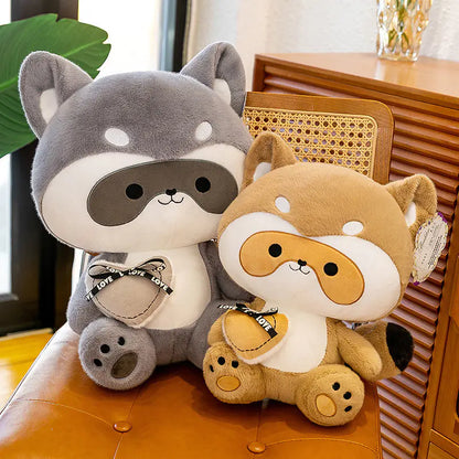 Two plush toys, one gray and one brown, sitting on a chair with a blurred background.