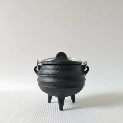 Black cast iron pot with lid on a white background