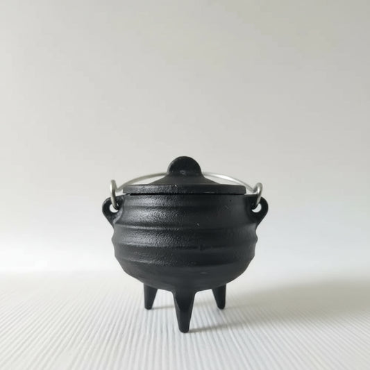 Black cast iron pot with lid on a white background