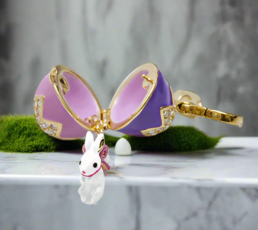 Purple bow-shaped jewelry with a small bunny charm on a white background