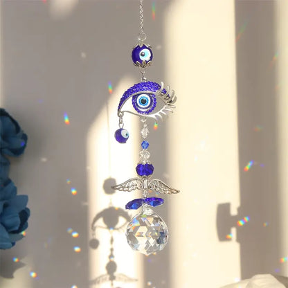 Decorative hanging ornament with eye design and crystal ball on a light background