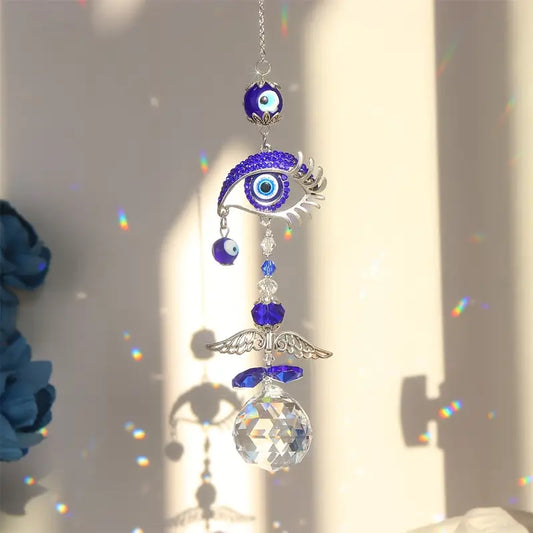 Decorative hanging ornament with eye design and crystal ball on a light background