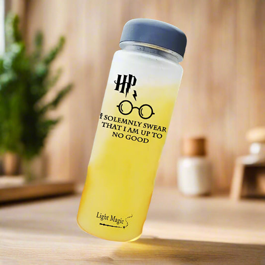 Yellow water bottle with HP branding held by a hand by a body of water
