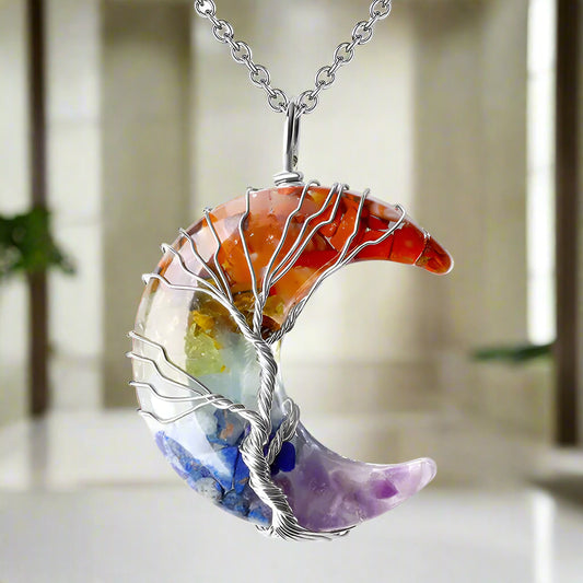 Multicolored crescent moon pendant with silver tree design on a white background