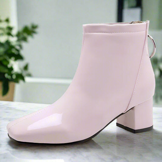 Pink ankle boot with a block heel on a white background