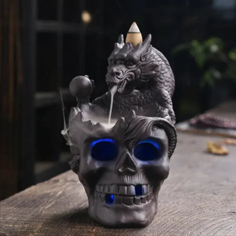 Dragon and skull design incense burner on a wooden surface