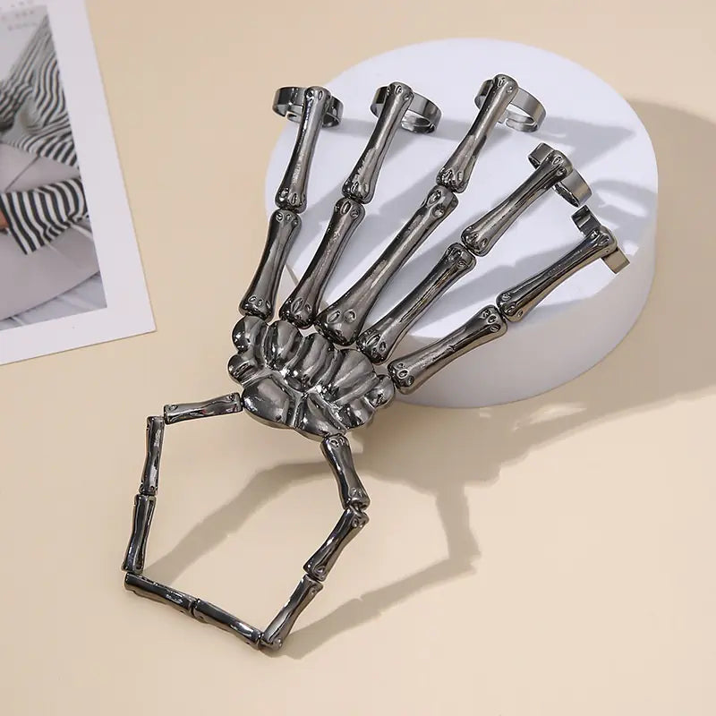 Metallic skeleton hand on a beige background
