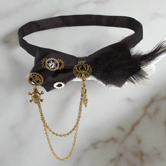 Black ribbon choker with gold accents and feathers on a white background