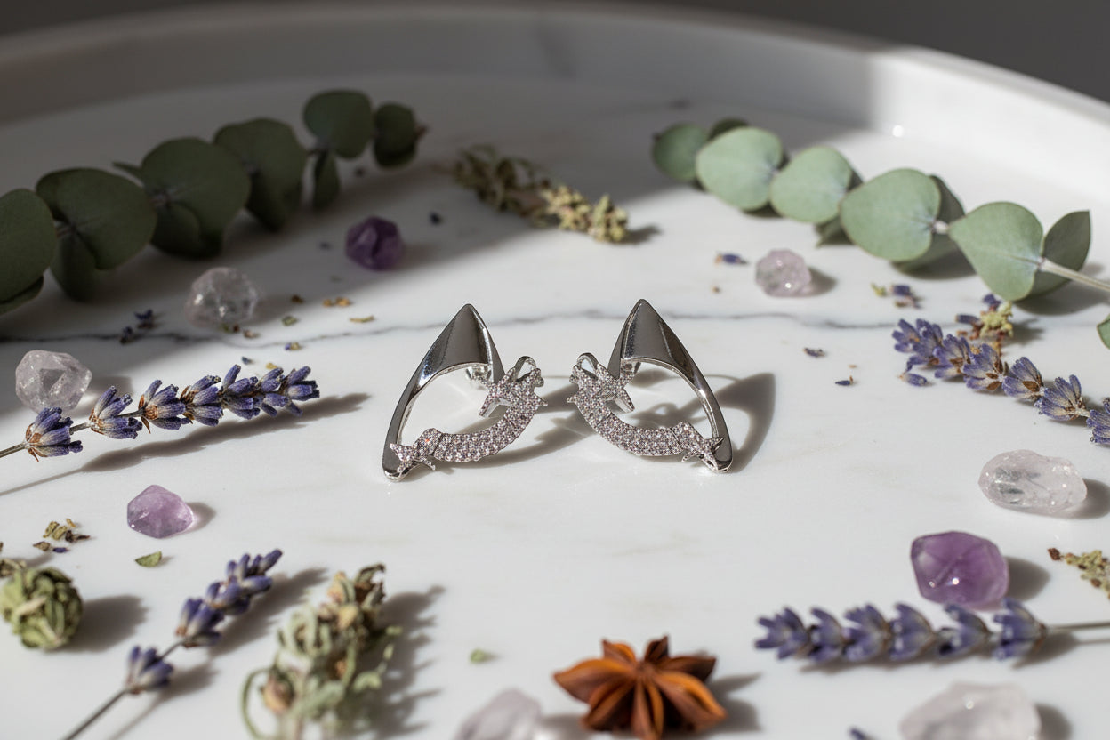 Pair of silver spike earrings with clear gemstones on a white background