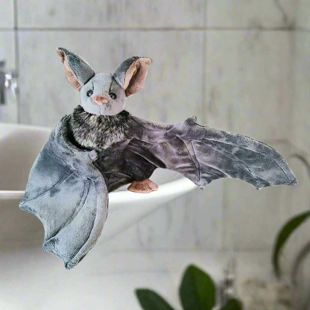 Plush toy bat with gray wings and brown head on a white background