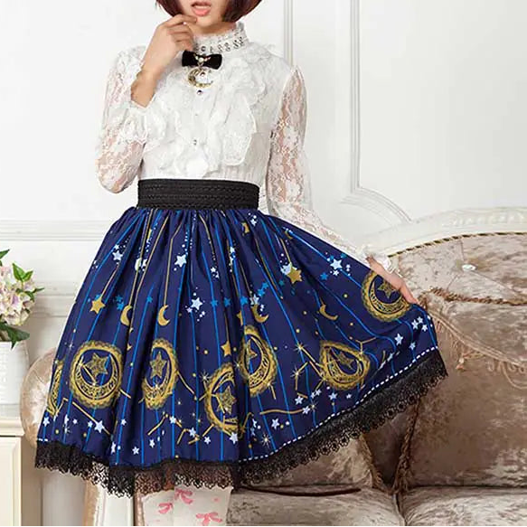 Woman wearing a white lace top and blue skirt with star and moon patterns, sitting on a couch.