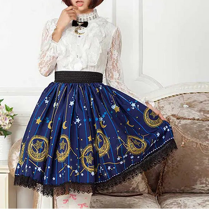 Woman wearing a white lace top and blue skirt with star and moon patterns, sitting on a couch.