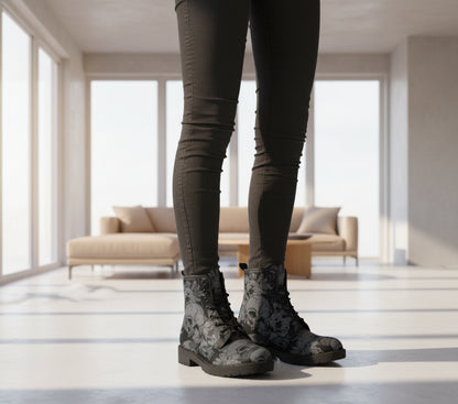 Black floral and skull patterned boots worn by a person on a white background